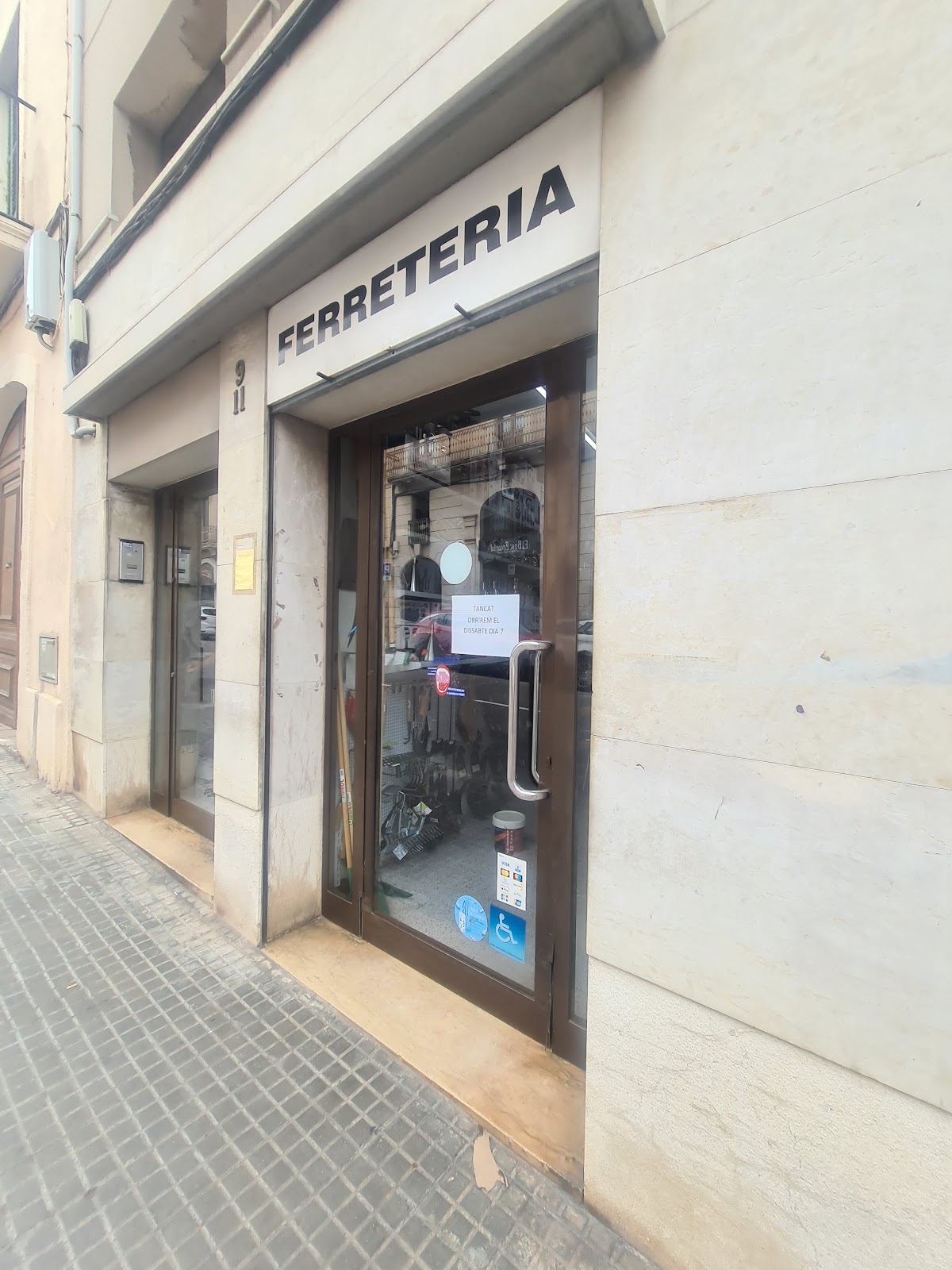 Porta d'entrada de la ferreteria, als números 9-11 del carrer d'Hermenegild Clascar